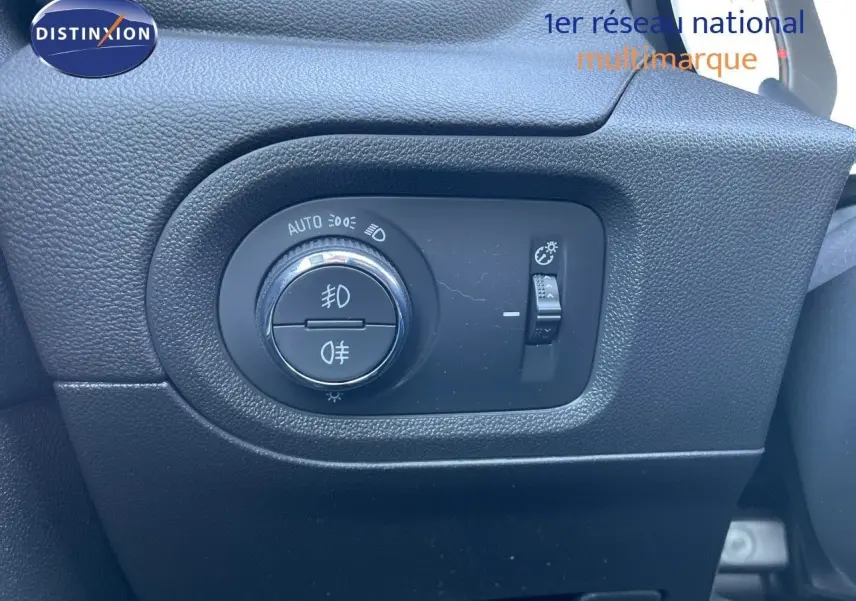 Gros plan sur le bouton de commande des phares dans l'habitacle d'un Opel Grandland X gris quartz metal.