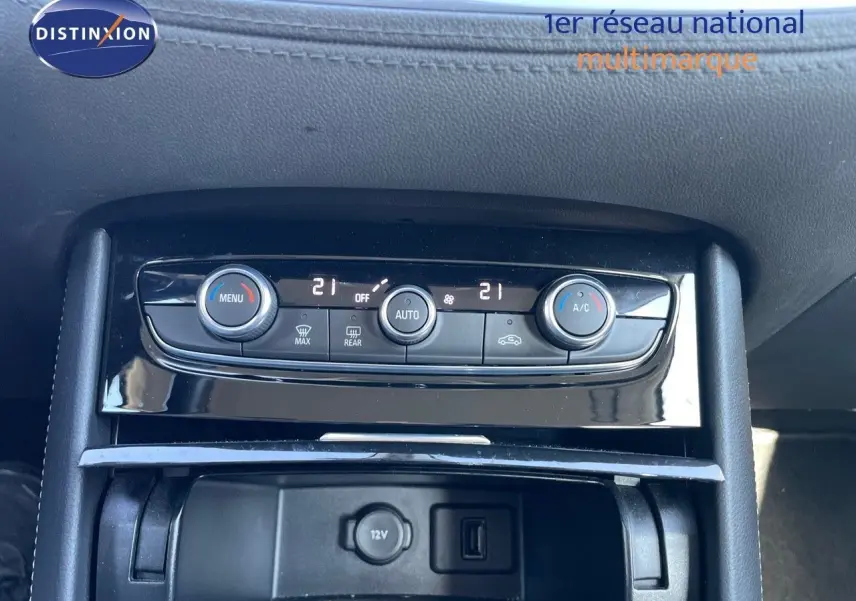 Console centrale de l'Opel Grandland X 2021 montrant les commandes de climatisation et prise 12V en noir brillant.