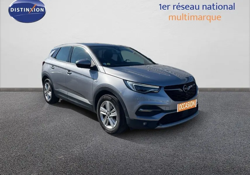 Opel Grandland X gris quartz métal en 3/4 avant droit, avec calandre noire et jantes alliage 17 pouces.