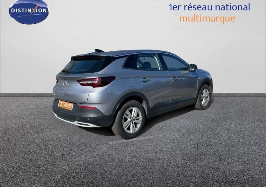 Opel Grandland X gris quartz métal vu en 3/4 arrière côté droit sur fond neutre avec plaque occasion.