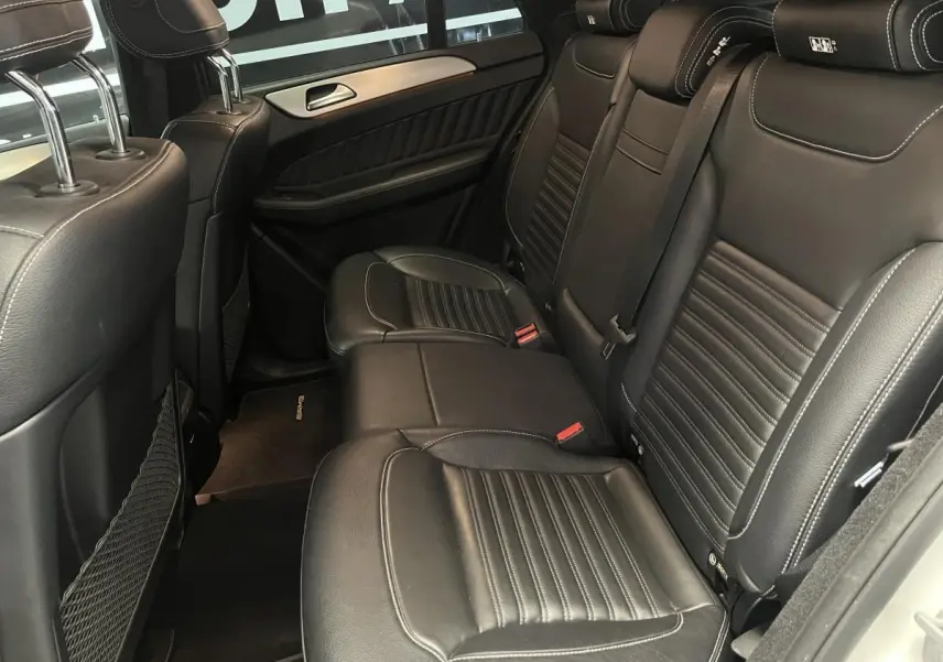 Vue intérieure de la banquette arrière en cuir noir du Mercedes GLE Coupé 350 d Sportline blanc, avec appuie-têtes AMG.