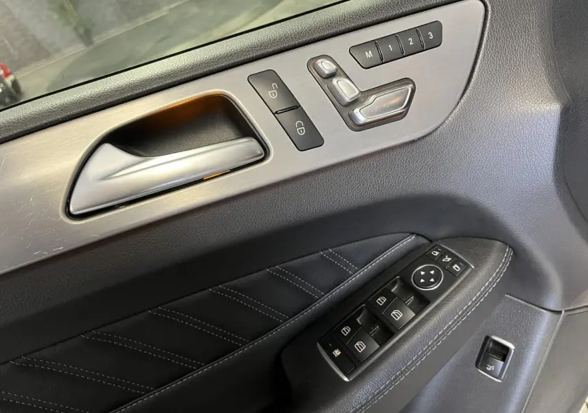 Détail de la porte intérieure côté conducteur du Mercedes GLE Coupé blanc, avec commandes électriques et réglages mémoire.