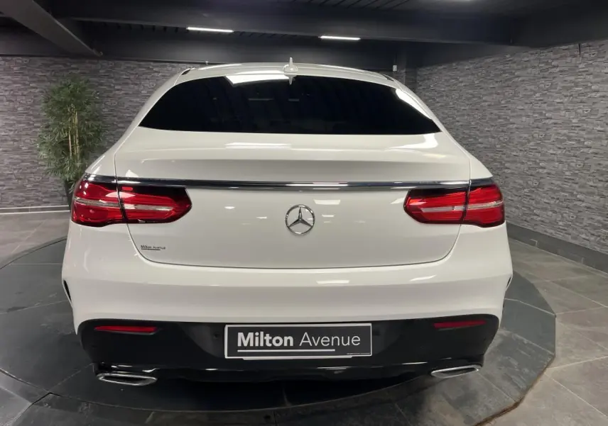 Vue arrière d'un Mercedes GLE Coupé blanc avec feux rouges et double sortie d'échappement chromée.