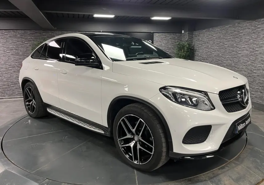 Mercedes GLE Coupé blanc en 3/4 avant droit avec jantes AMG noires et coques de rétroviseurs noires brillantes
