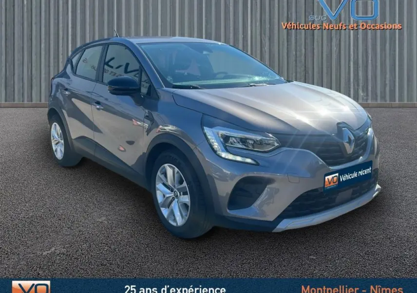 Renault Captur TCe 90 Business gris vu en 3/4 avant droit avec feux LED et jantes alliage sur fond neutre.