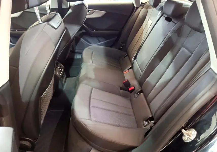 Vue côté droit de la banquette arrière noire de l'Audi A5 35 TFSI 2021 avec appuie-têtes et ceintures visibles.