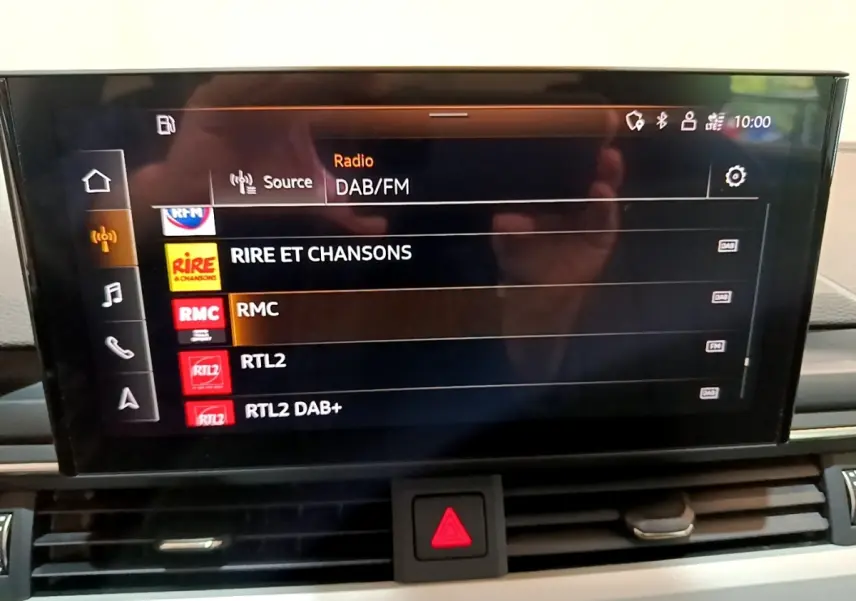 Écran central tactile de l'Audi A5 35 TFSI 2021 affichant la liste des radios DAB/FM en intérieur noir.