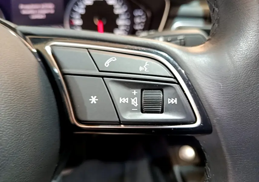 Gros plan sur les commandes audio et téléphone au volant cuir noir de l'Audi A5 35 TFSI 2021.