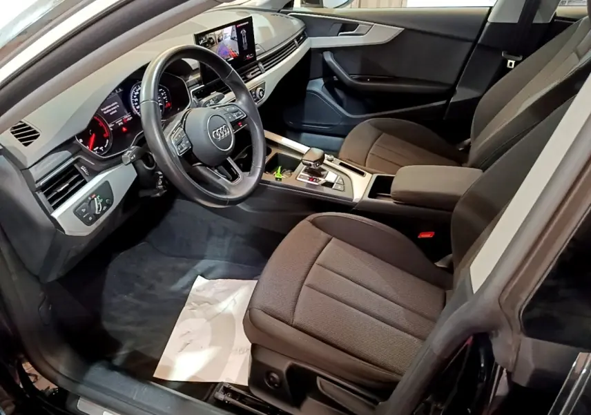 Vue intérieure côté conducteur de l'Audi A5 35 TFSI 2021 avec tableau de bord digital et sièges tissu noirs.