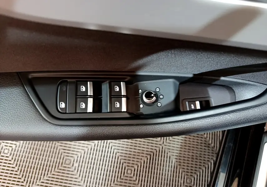 Commande des vitres et réglage des rétroviseurs côté gauche sur la portière noire d'une Audi A5 2021.