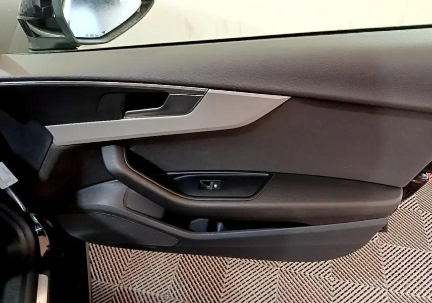 Vue rapprochée de la porte côté conducteur noire de l'Audi A5 35 TFSI 2021 avec insert argenté et poignée intégrée.