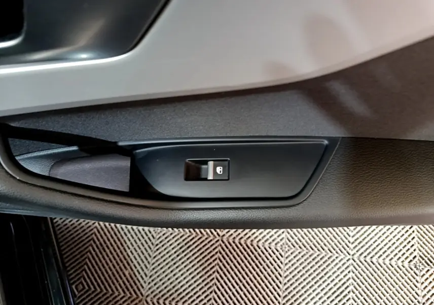 Bouton de verrouillage des portes sur la portière côté gauche d'une Audi A5 noire, vue en gros plan intérieur.