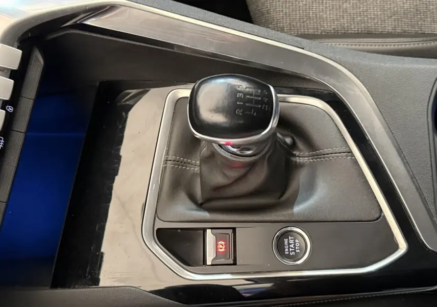 Vue rapprochée de la console centrale avec levier de vitesse manuel noir et bouton démarrage Peugeot 5008 bleu.