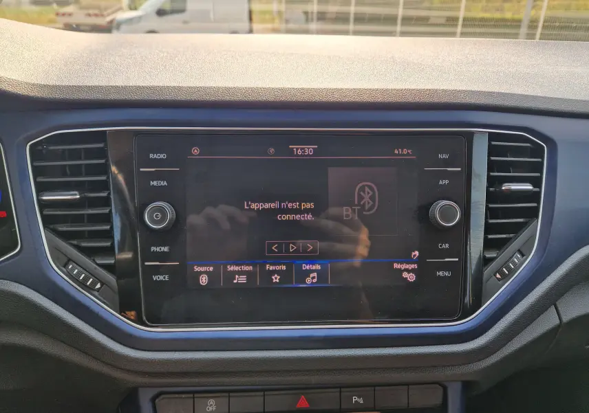 Vue rapprochée de l’écran central tactile du Volkswagen T-Roc gris foncé, affichant un message Bluetooth non connecté.