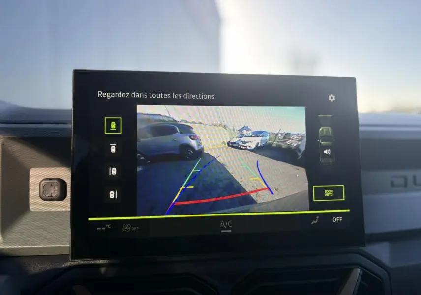 Écran central tactile affichant la caméra multivues avec vue arrière et lignes de guidage du Dacia Duster 2026.