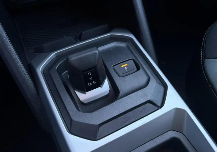 Gros plan sur la console centrale du Dacia Duster 2026, montrant le levier de boîte auto et le bouton de parking.