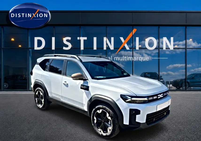 SUV Dacia Bigster blanc en 3/4 avant droit, avec barres de toit et jantes alu noires et argentées.