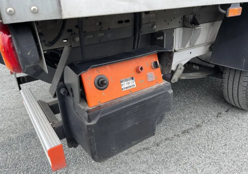 Gros plan sous le coffre arrière droit du FIAT Ducato Maxi Business blanc, montrant un boîtier de commande orange et noir.