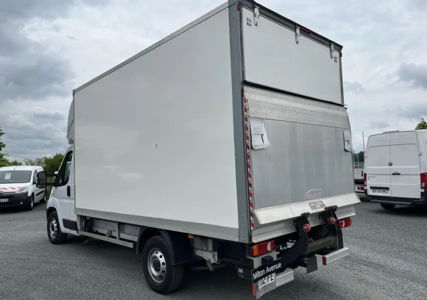 FIAT Ducato Fourgon blanc vu en 3/4 arrière droit avec grande caisse de chargement fermée en métal.
