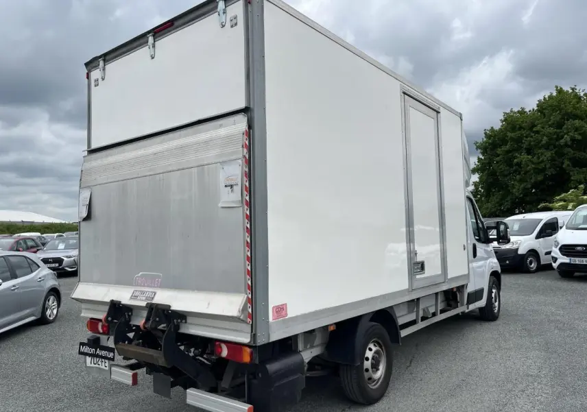 FIAT Ducato Fourgon blanc vu en 3/4 arrière droit, avec grande caisse de chargement et hayon élévateur métallique.