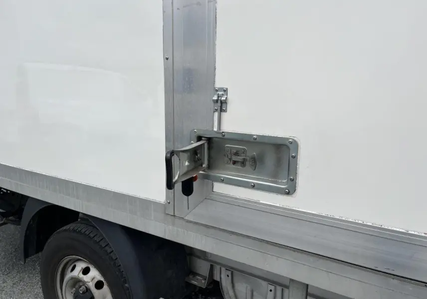 Détail de la poignée de porte latérale en métal sur la caisse blanche du FIAT Ducato Fourgon Maxi Business 2021.