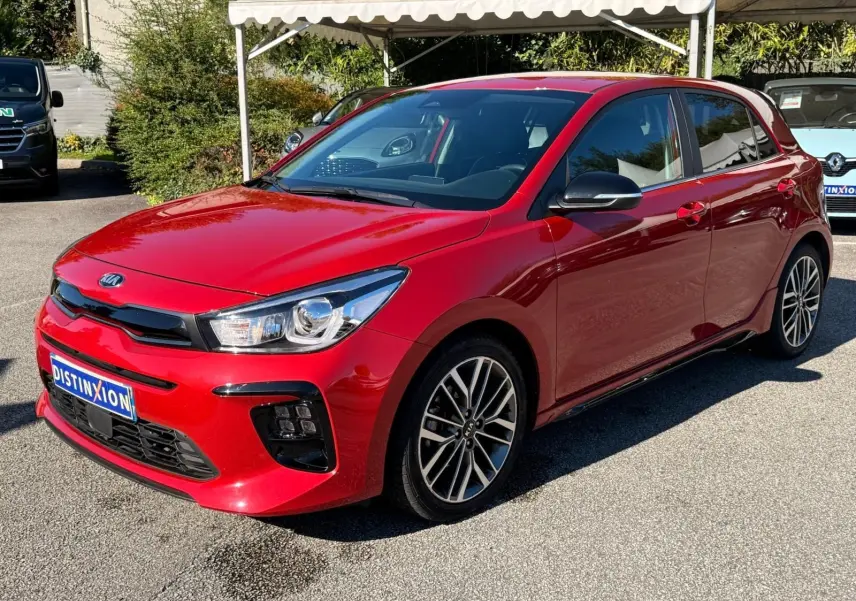 KIA Rio rouge grenadine vue 3/4 avant droit, mettant en valeur ses jantes alliage et son design dynamique.