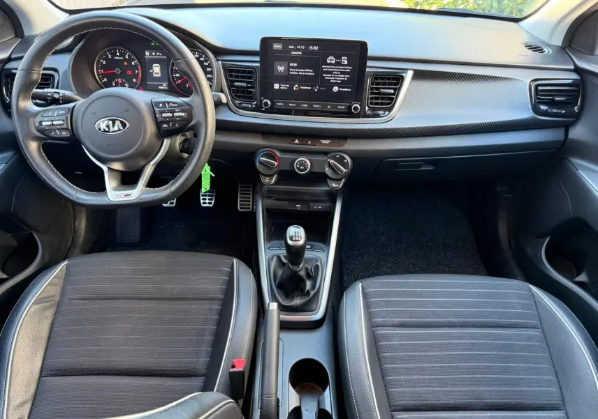 Intérieur de la KIA RIO 2022 GT-LINE, vue frontale du tableau de bord avec volant multifonctions et boîte manuelle.