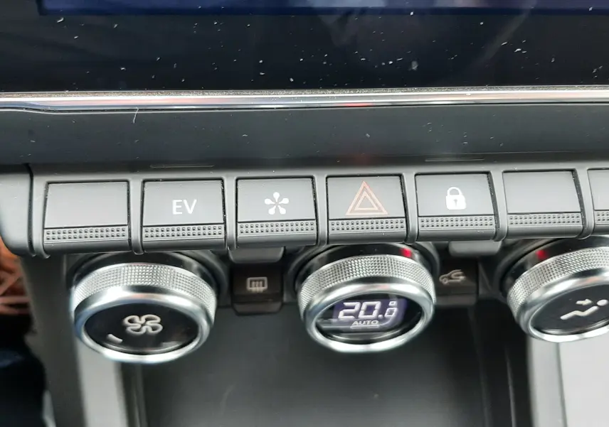 Vue rapprochée de la console centrale du Renault Arkana 1.6 E-TECH 145 Intens, boutons de climatisation et écran tactile.