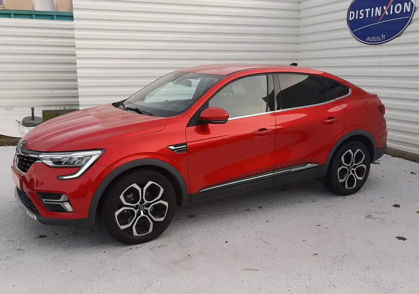 Renault Arkana 1.6 E-TECH 145 Intens rouge Flame vu de profil côté gauche, avec jantes bi-ton et vitres teintées.