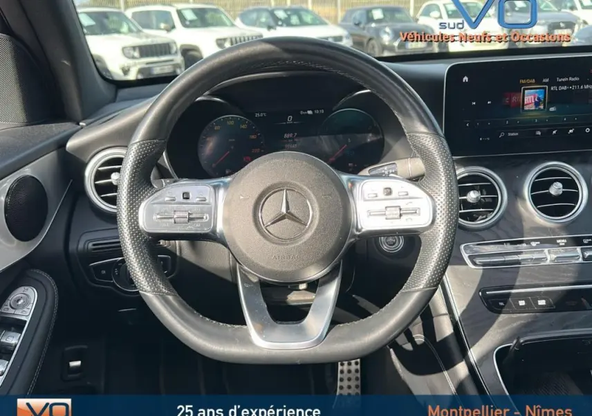 Vue intérieure centrée sur le volant sport Mercedes GLC 300 de gris anthracite avec tableau de bord numérique et écran tactile.