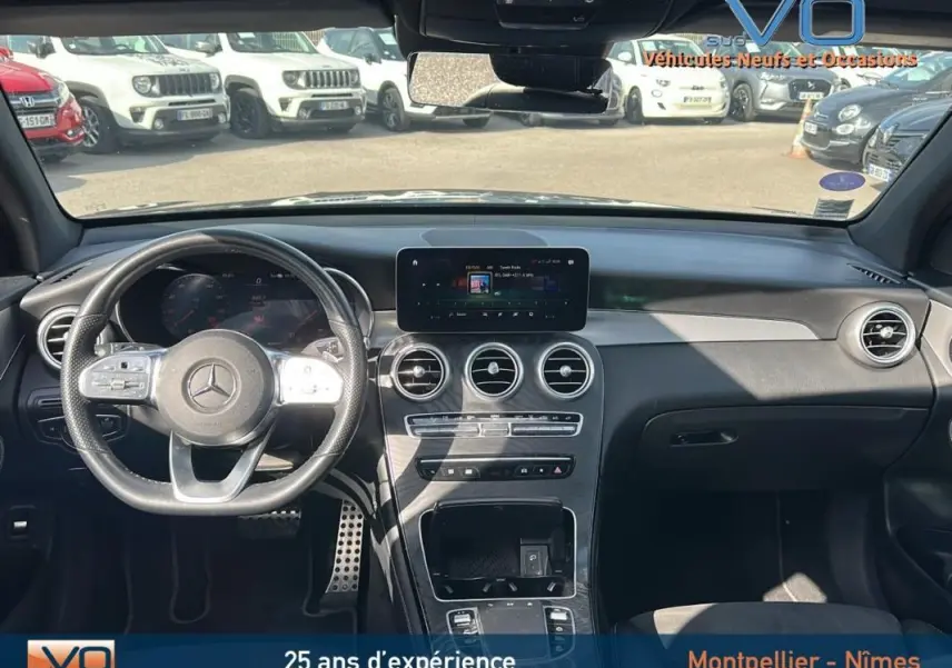 Vue intérieure avant du Mercedes GLC 300 de 2020, volant sport, écran tactile central et finition noire élégante.