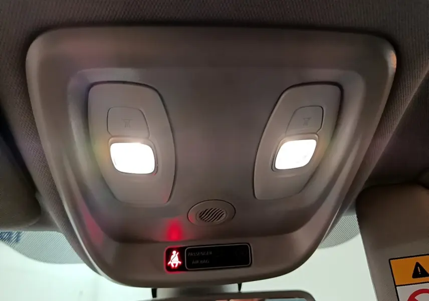 Plafonnier intérieur avec lampes allumées et témoin d'airbag passager dans un Renault Captur orange 2019.