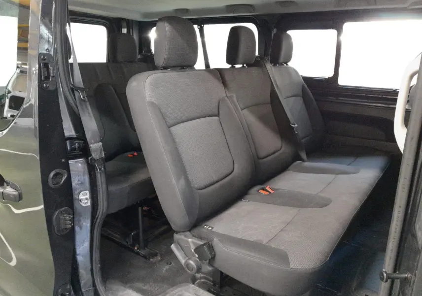 Vue intérieure côté droit du Renault Trafic Combi gris comète, montrant les sièges passagers en tissu gris.