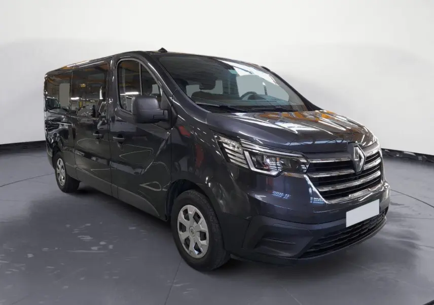 Renault Trafic Combi gris comète, vue 3/4 avant droit, mettant en valeur ses phares modernes et sa calandre chromée.