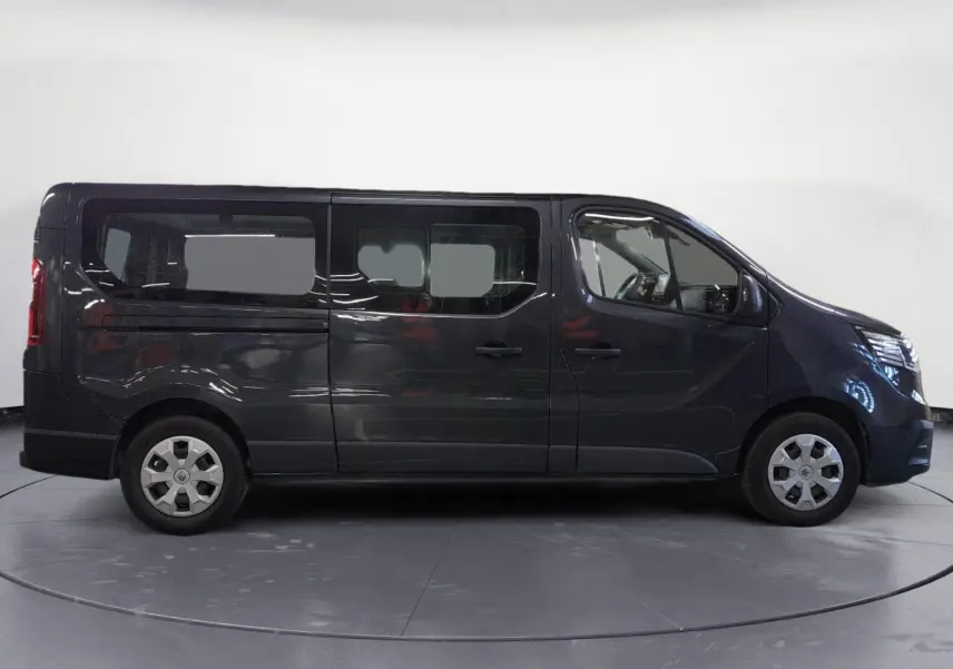 Profil droit du Renault Trafic Combi gris comète 2022, version L2 9 places, avec grandes fenêtres latérales.