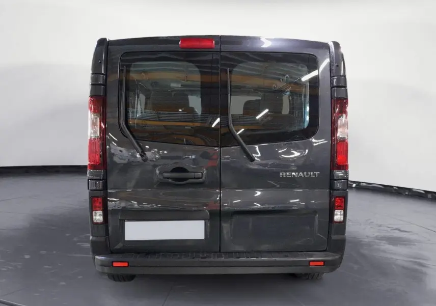 Vue arrière du Renault Trafic Combi gris comète 2022 avec portes battantes et essuie-glaces arrière visibles.