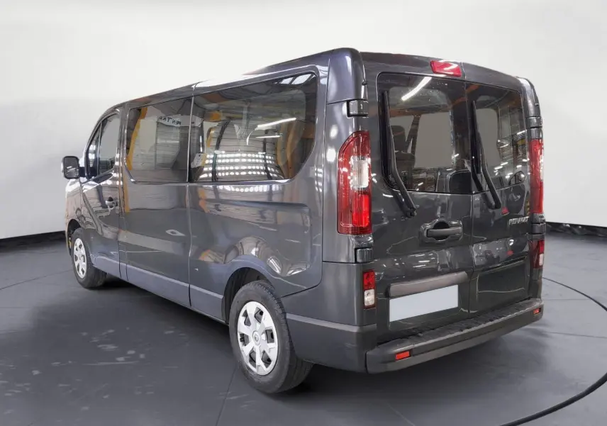 Renault Trafic Combi gris comète vu en 3/4 arrière droit, avec vitres latérales et portes arrière vitrées.