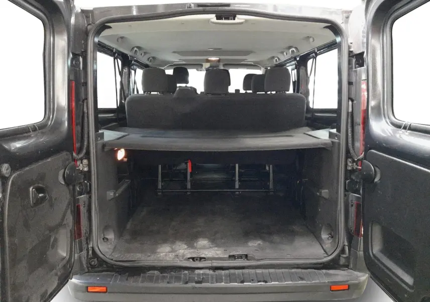 Vue arrière ouverte du Renault Trafic Combi gris comète, montrant l'espace de chargement et les sièges passagers à l'intérieur.