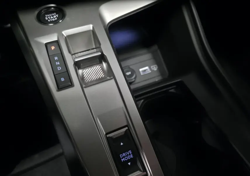 Gros plan sur la console centrale grise avec sélecteur de boîte auto et bouton Drive Mode de la Peugeot 408 noire.