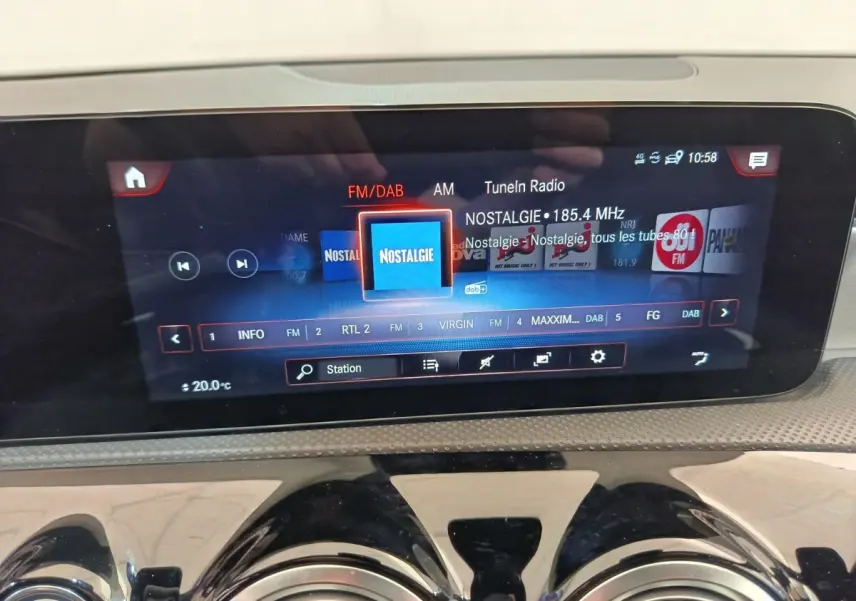Écran tactile central du tableau de bord de la Mercedes Classe A blanche, affichant la radio FM/DAB.