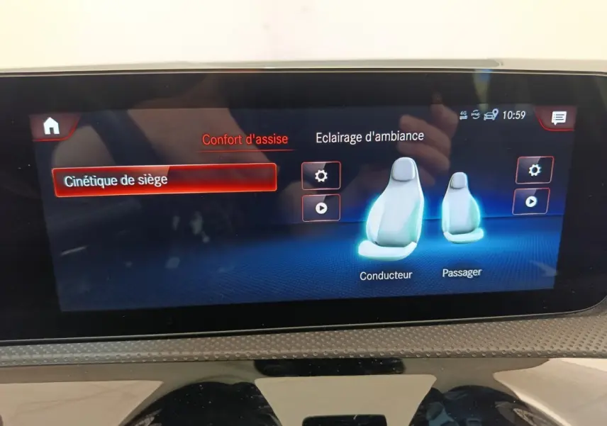 Écran tactile intérieur de la Mercedes Classe A blanc, affichant les réglages de confort d’assise et éclairage d’ambiance.