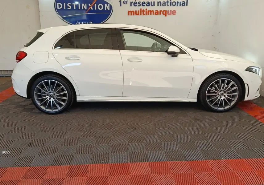 Profil droit d'une Mercedes Classe A 250 e AMG Line blanche, avec jantes alliage et rétroviseurs électriques rabattables.