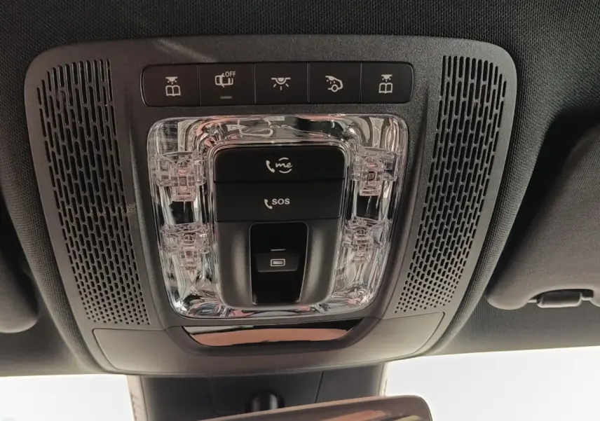 Vue en plongée sur le plafonnier intérieur noir avec commandes SOS et éclairage d'une Mercedes Classe A blanche.