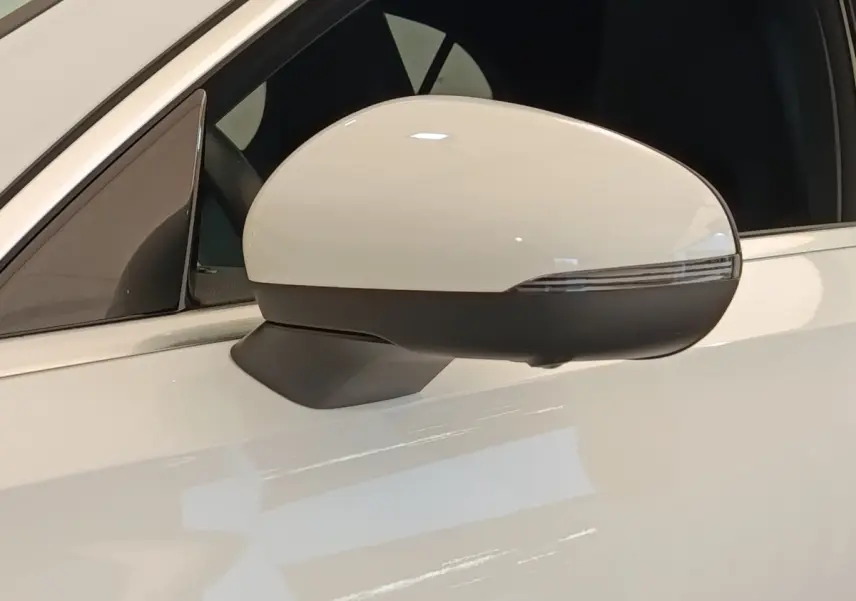 Gros plan sur le rétroviseur droit blanc et noir d’une Mercedes Classe A 250 e AMG Line 2021 hybride rechargeable.