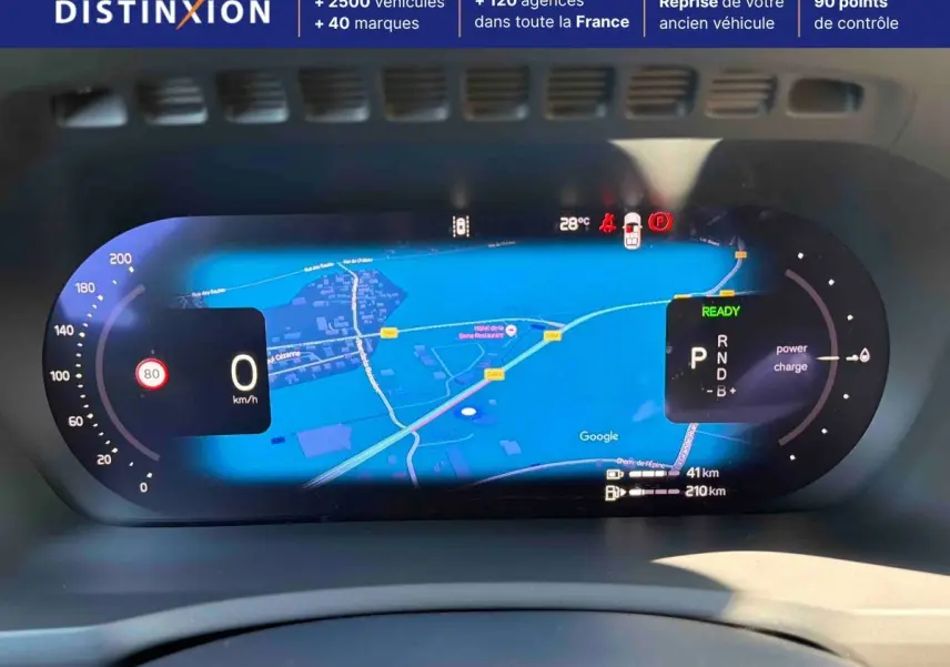 Affichage numérique du tableau de bord du Volvo XC90 hybride, montrant la navigation et les indicateurs de vitesse et de charge.