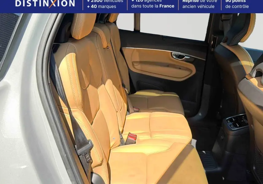 Vue intérieure côté gauche des sièges arrière en cuir beige du Volvo XC90 T8 hybride 2024 avec portières ouvertes.