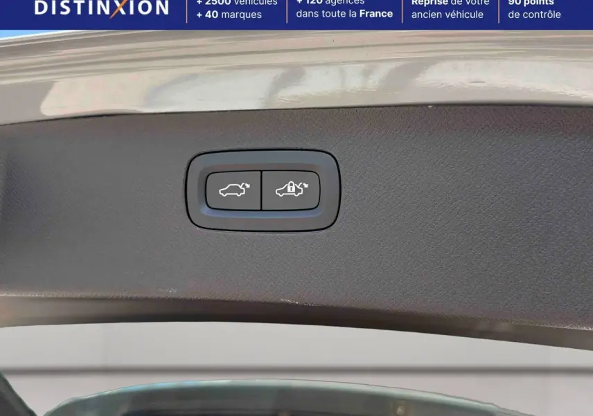 Boutons d'ouverture et de verrouillage électrique du hayon sur un Volvo XC90 gris, vue intérieure du coffre ouvert.