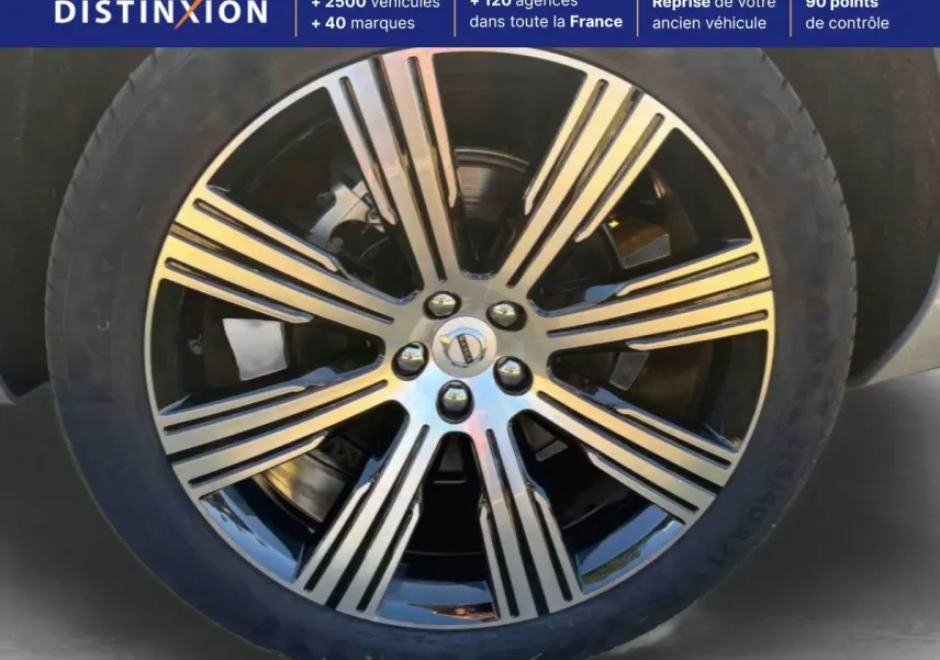 Gros plan sur la jante alliage 21 pouces noir et diamant du Volvo XC90 gris, mettant en valeur son design à 8 branches.