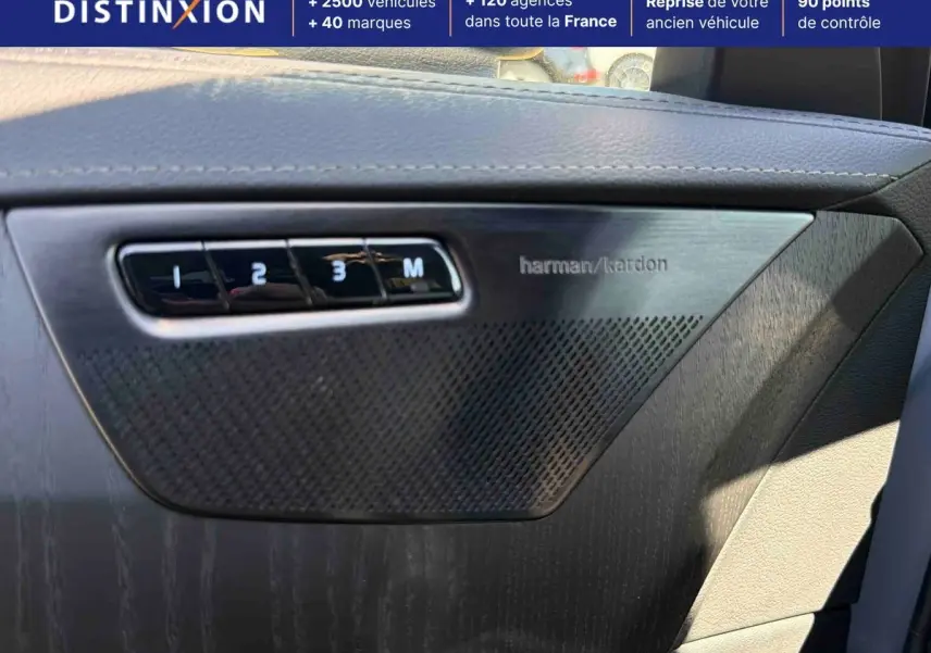 Détail intérieur montrant la porte côté droit avec haut-parleur Harman Kardon et boutons mémoire sur Volvo XC90 gris.