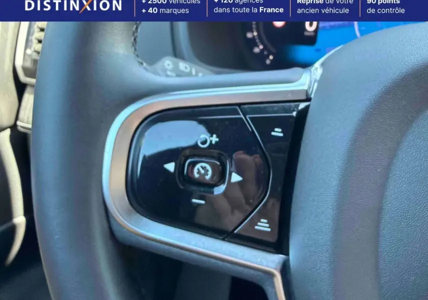 Gros plan sur les commandes du volant côté gauche d’un Volvo XC90 gris, avec régulateur de vitesse.